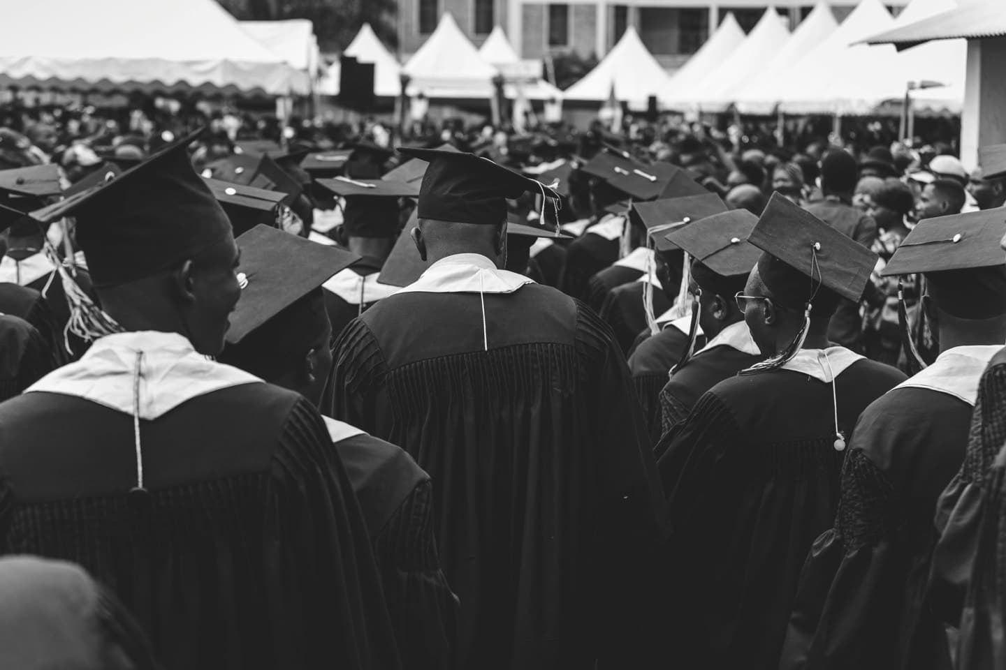 Graduates celebrating at graduation ceremony holding diplomas